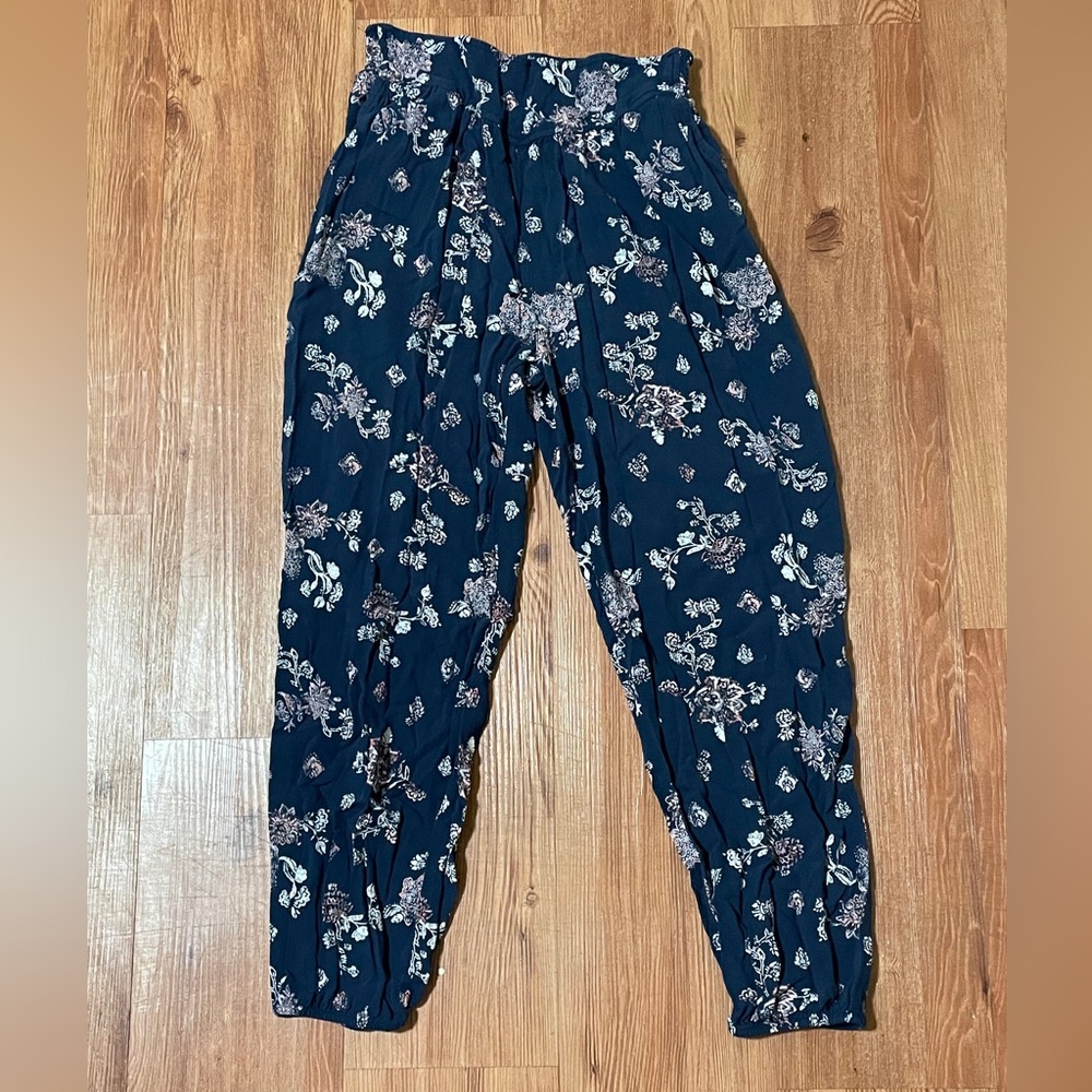 Small blue pair of flowy pants with white and pink flowers with pockets